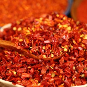 Three-variety ground chili blend on a wooden spoon