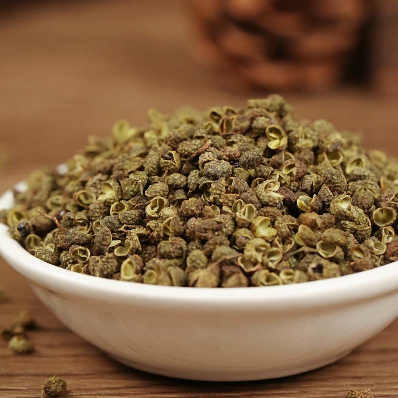 Green Sichuan peppercorns in a white bowl