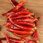 Huaxi dried chili peppers on a wooden scoop