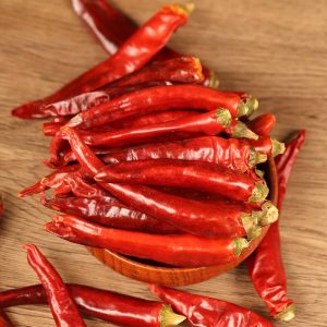 Huaxi dried chili peppers on a wooden scoop