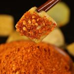 Five-spice chili dipping seasoning coating a piece of grilled potato
