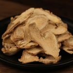 Dried ginger slices on a black plate