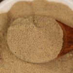 Ground white pepper on a wooden spoon