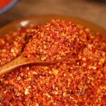 Five-variety ground chili blend on a wooden spoon