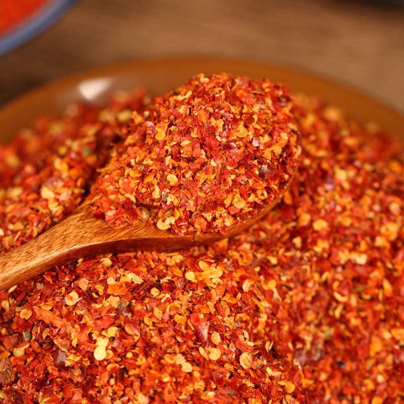 Five-variety ground chili blend on a wooden spoon