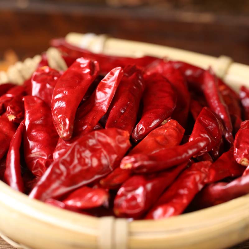 Xinyidai dried chili peppers in a bamboo sieve