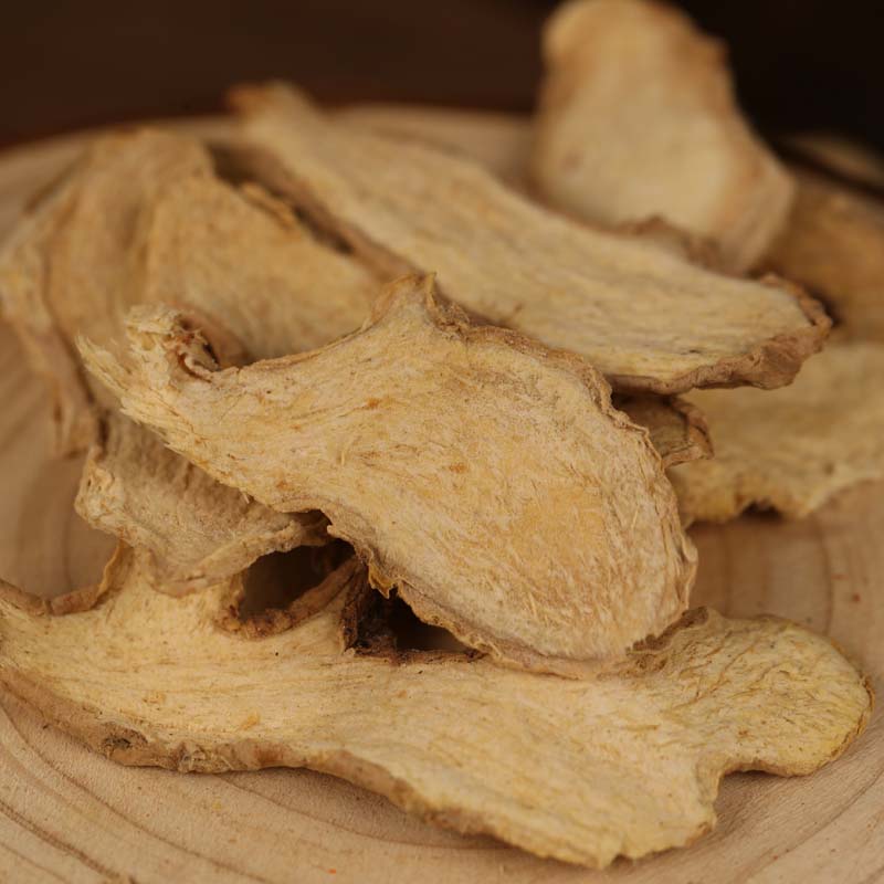 Dried ginger slices on a wooden table