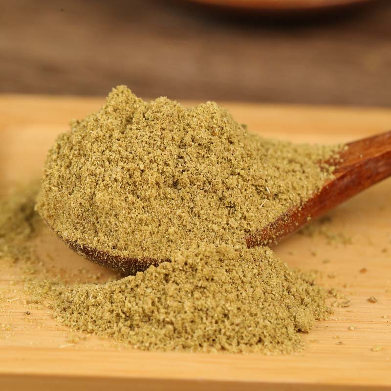 Ground fennel on a wooden board with a spoon