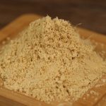 Ground ginger mounded on a wooden board