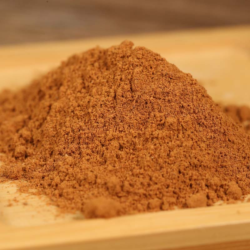 Ground cinnamon mounded on a wooden board
