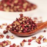 Meihua red Sichuan peppercorns on a wooden spoon