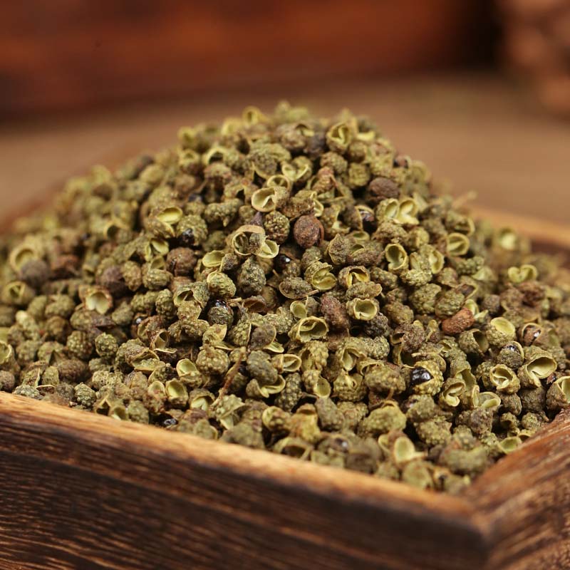 Green Sichuan peppercorns on a wooden tray