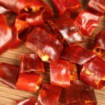Huaxi dried chili segments scattered on a wooden table