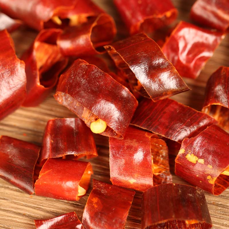 Huaxi dried chili segments scattered on a wooden table