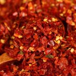 Xiaomila crushed chili flakes on a wooden spoon