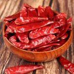 Xinyidai dried chili peppers in a wooden bowl