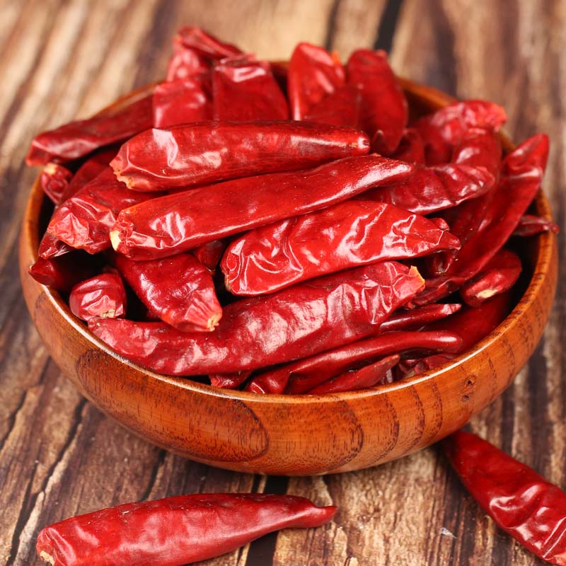 Xinyidai dried chili peppers in a wooden bowl
