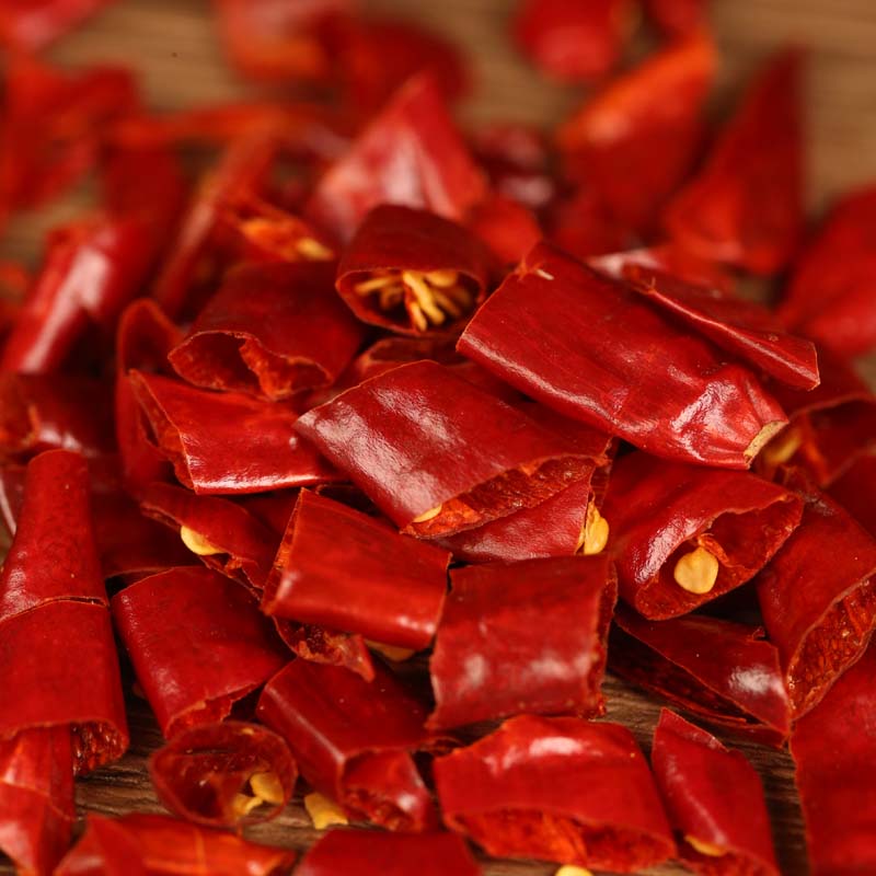 Xinyidai dried chili segments scattered on a wooden table