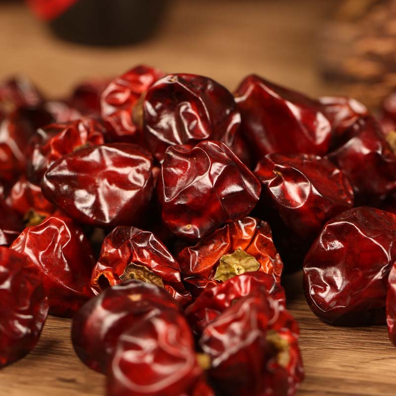 Denglongjiao dried chili peppers heaped on a wooden table