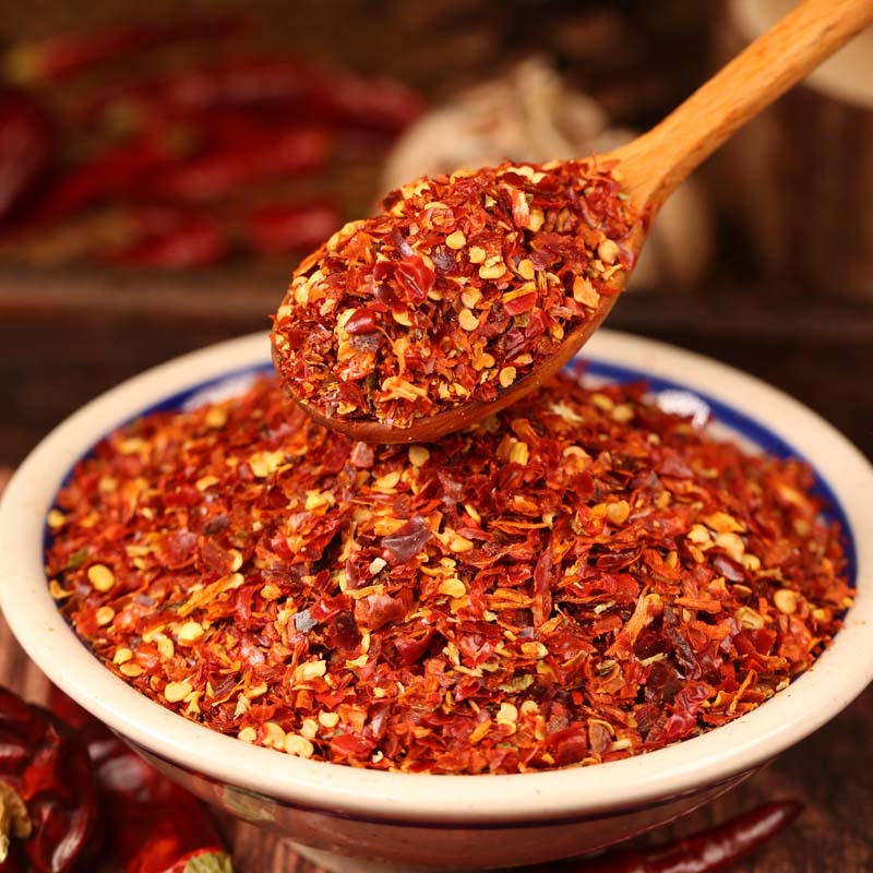 Huaxi coarse-ground chili powder on a wooden spoon