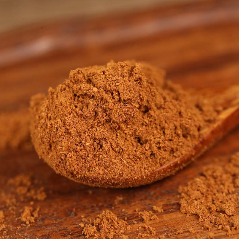 Ground star anise on a wooden spoon on a table