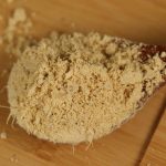 Ground ginger on a wooden spoon
