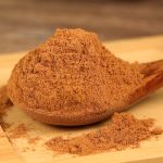 Ground cinnamon on a wooden spoon
