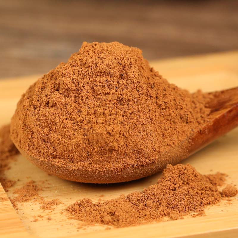 Ground cinnamon on a wooden spoon