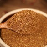 Red Sichuan pepper powder on a wooden spoon