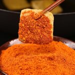 Mala chili dipping seasoning coating a skewered piece of food