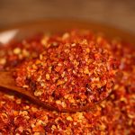 Five-variety ground chili blend heaped on a wooden spoon