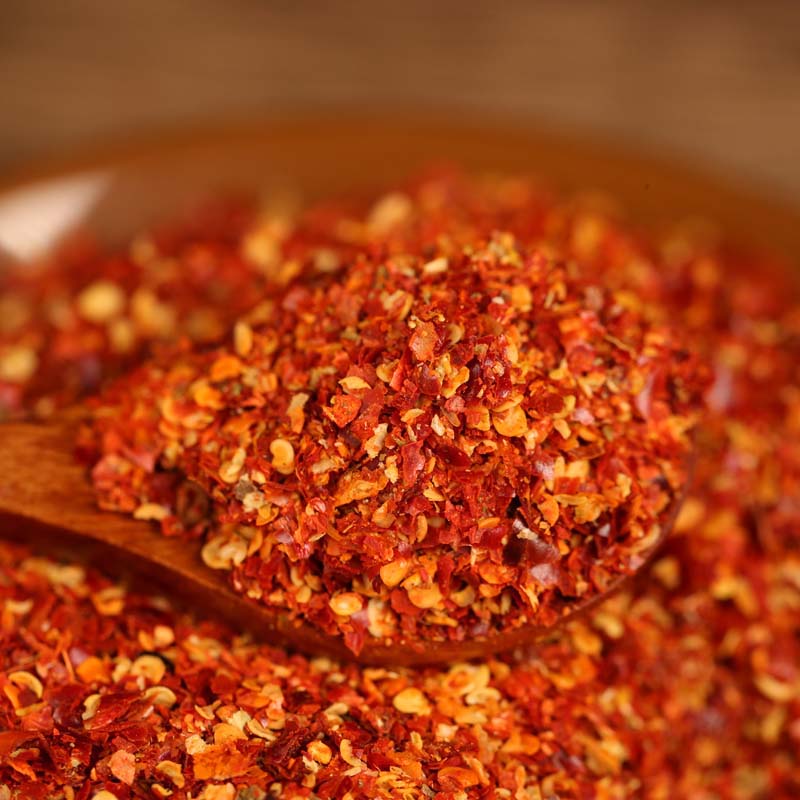 Five-variety ground chili blend heaped on a wooden spoon
