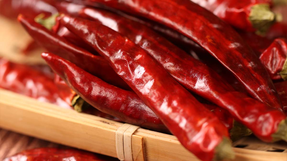 Whole dried red chili peppers on a bamboo tray