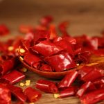 Xinyidai dried chili segments on a wooden spoon