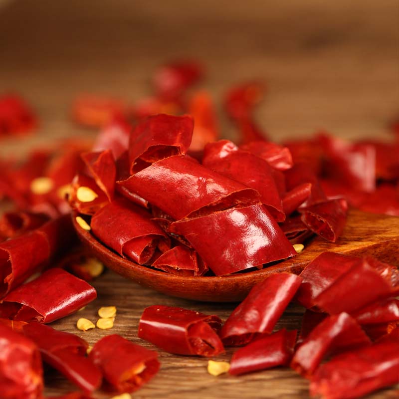 Xinyidai dried chili segments on a wooden spoon