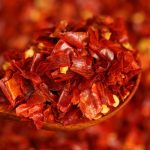 Three-variety ground chili blend close up on a wooden spoon