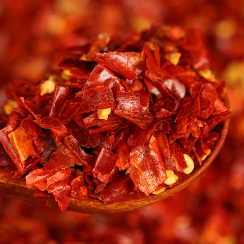 Three-variety ground chili blend close up on a wooden spoon