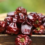 Denglongjiao dried chili peppers on a wooden board outdoors