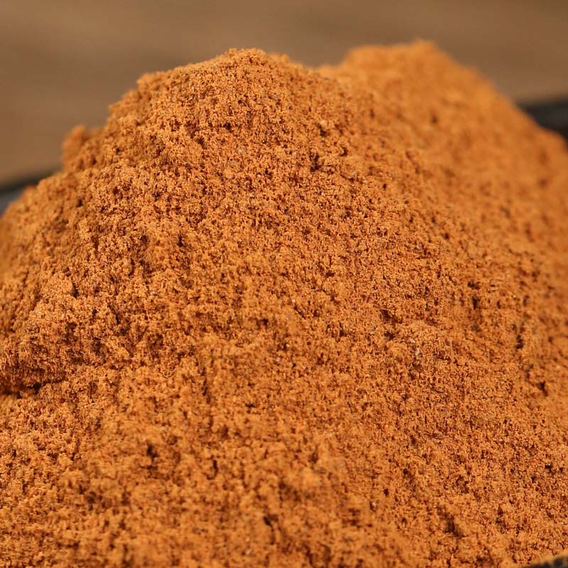 Ground cinnamon piled on a wooden board