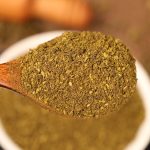 Green Sichuan pepper powder heaped on a wooden spoon