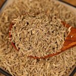 Cumin seeds on a wooden spoon