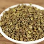 Green Sichuan peppercorns filling a white dish