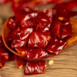 Xiaomila dried chili segments lifted on a wooden spoon