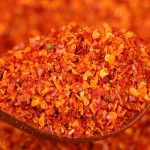 Close-up of super hot coarse chili powder on a wooden spoon