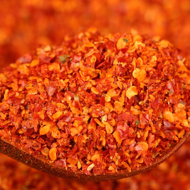 Close-up of super hot coarse chili powder on a wooden spoon
